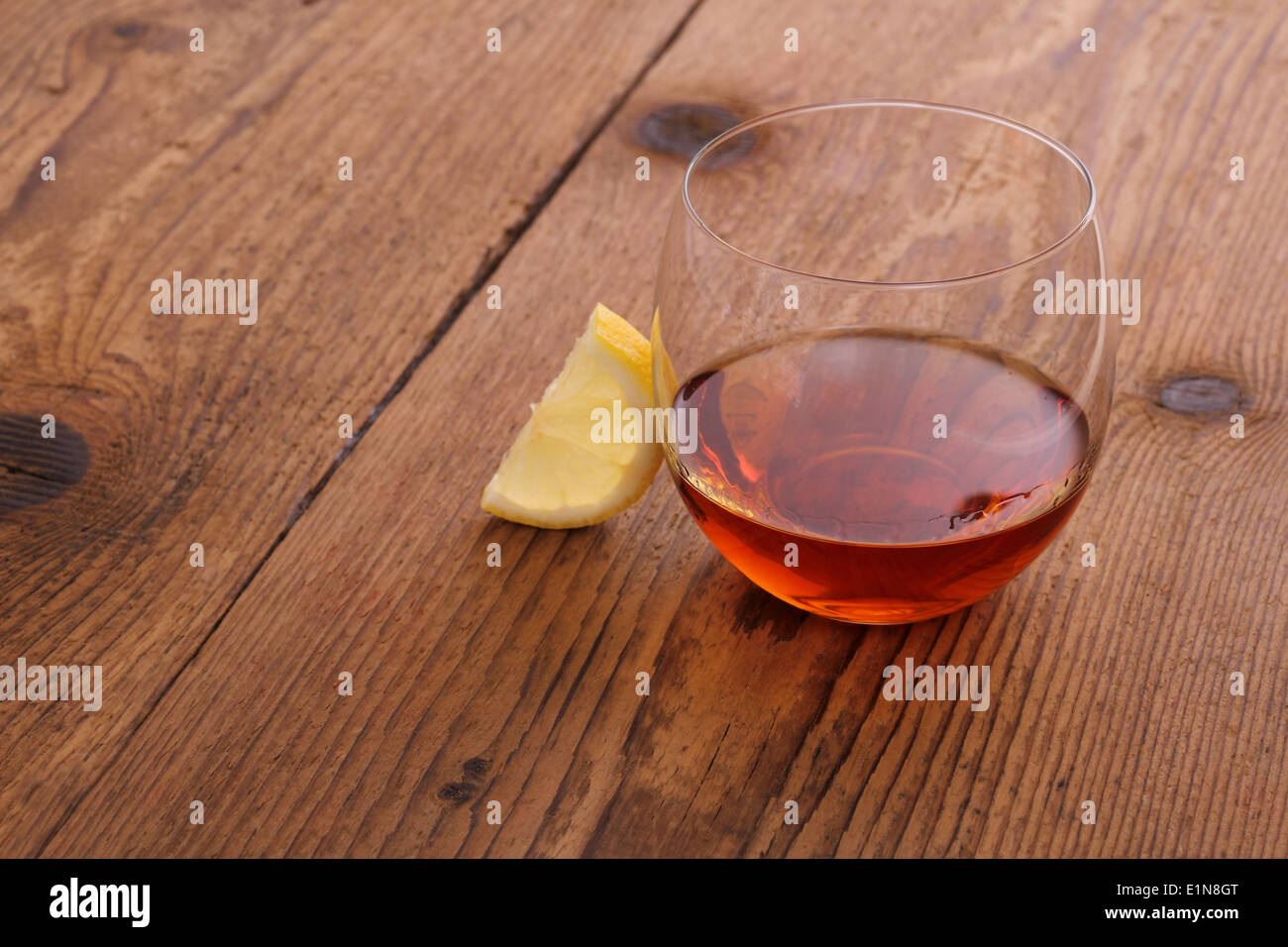 Il cognac di lusso in vetro decorativo su legno con il limone Foto Stock