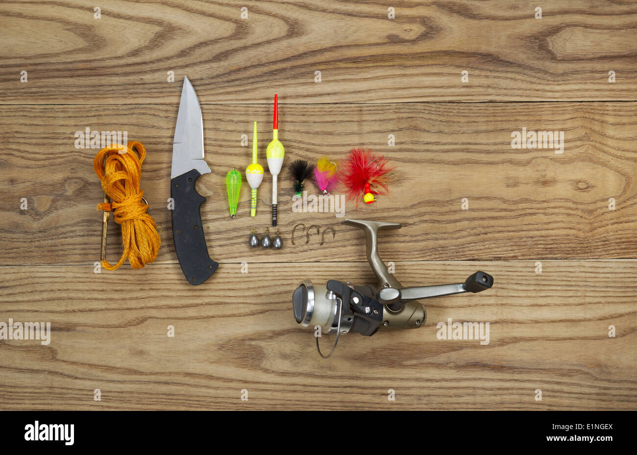 Parte superiore orizzontale visualizza foto di esche artificiali, bobber platine, ganci, coltello, aspo e stringer su legno sbiadito Foto Stock