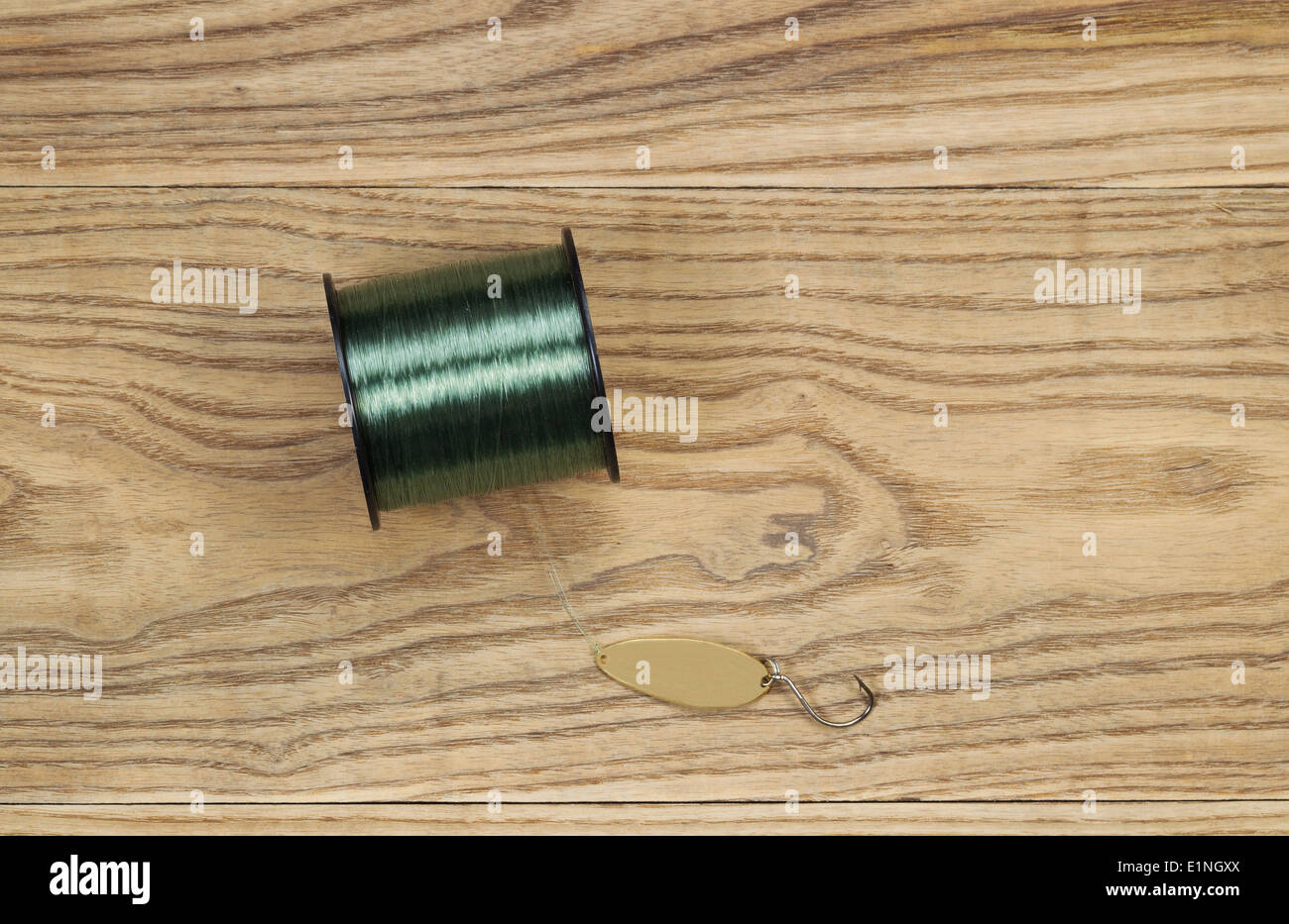 Parte superiore orizzontale visualizza foto di esca artificiale, piatto in metallo verniciato il cucchiaio d'oro e lo stelo di linea sul legno sbiadito Foto Stock