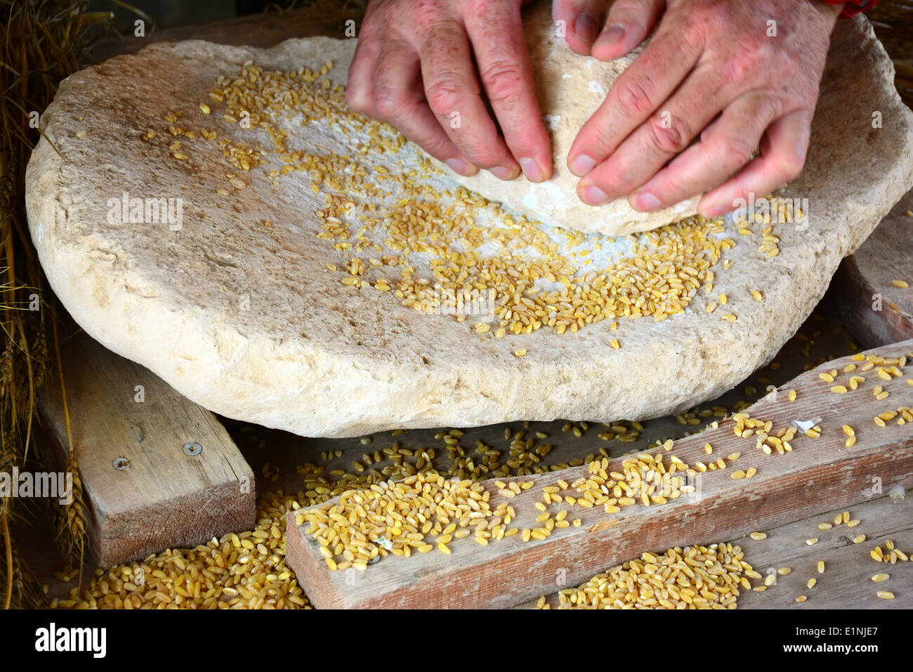 Macinazione del grano su una pietra di molatura Foto Stock