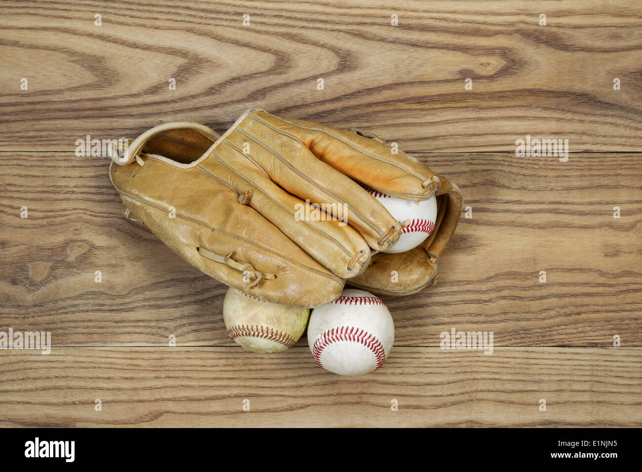 Parte superiore orizzontale Visualizza foto del vecchio Guanto baseball e le sfere sulla parte superiore di legno sbiadito Foto Stock