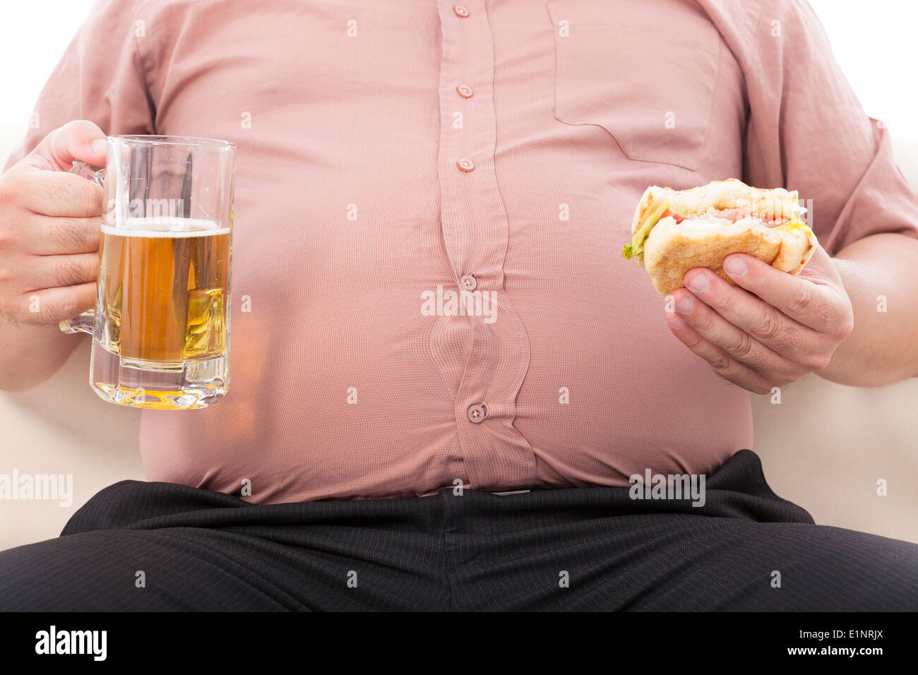 Fat business man holding boccale di birra e hamburger Foto Stock