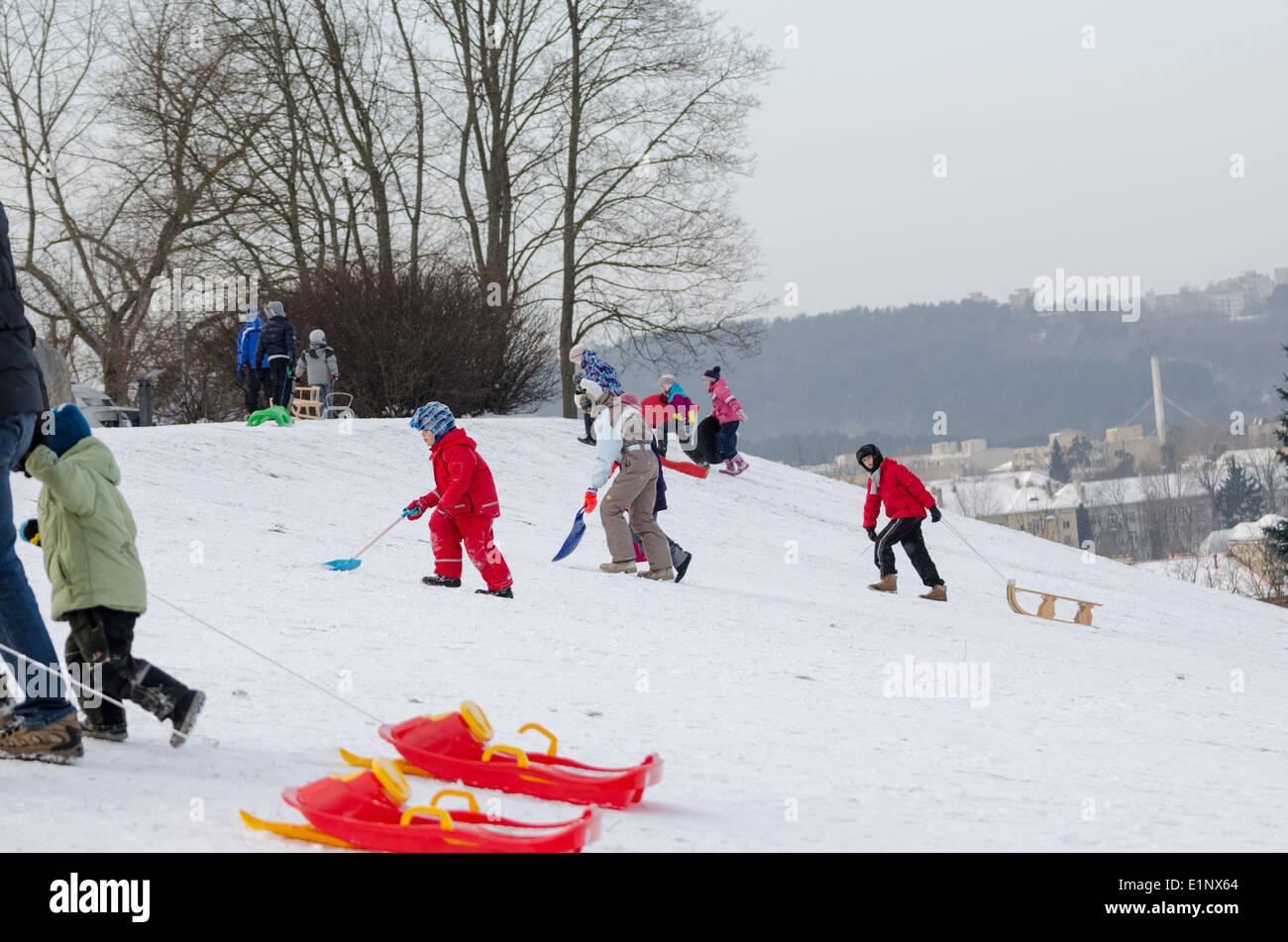 Bambini attivi divertimento in inverno sulla collina con lo slittino Foto Stock