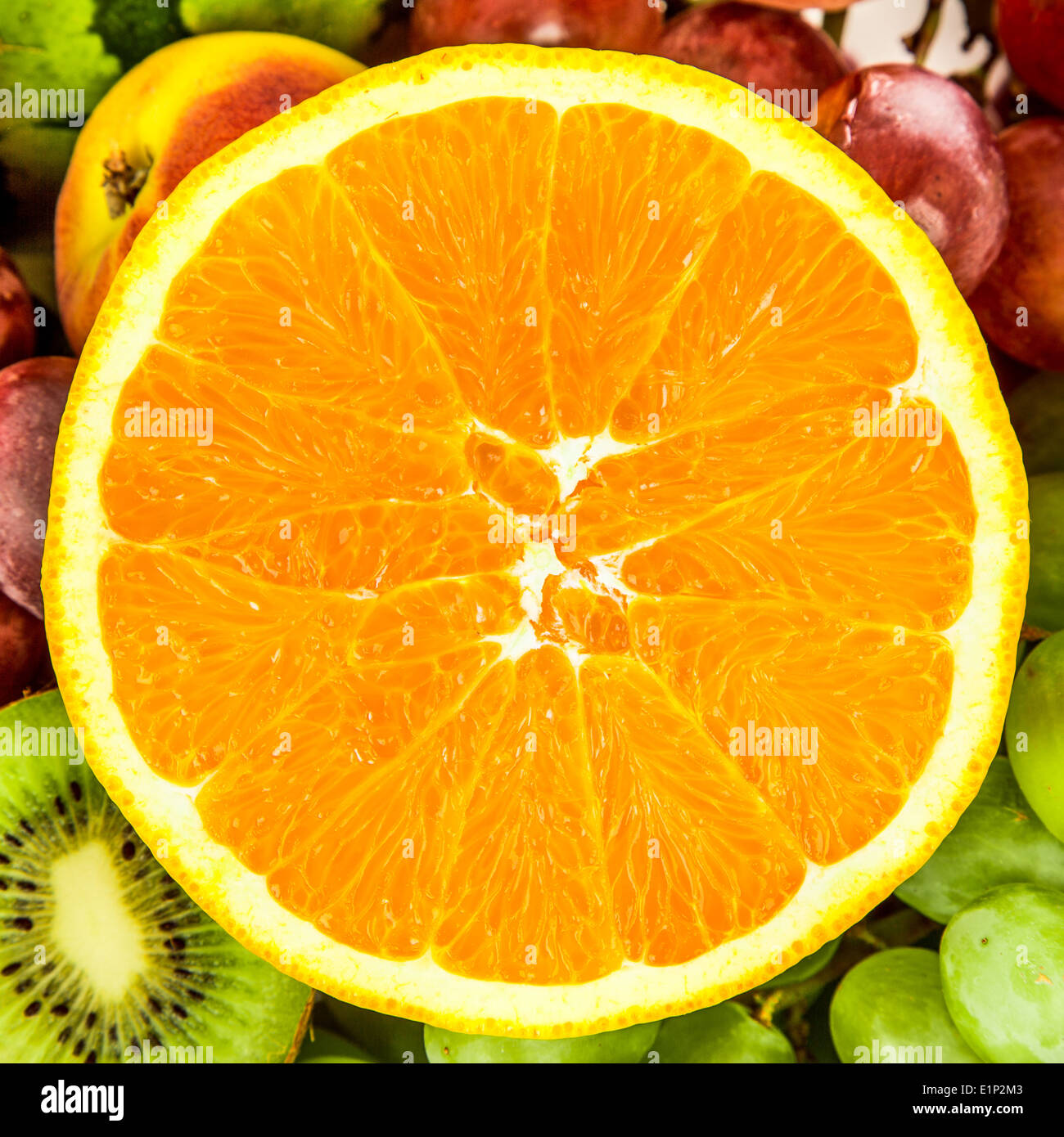 Succo di arancia su uno sfondo di diversi tipi di frutta e uva Foto Stock