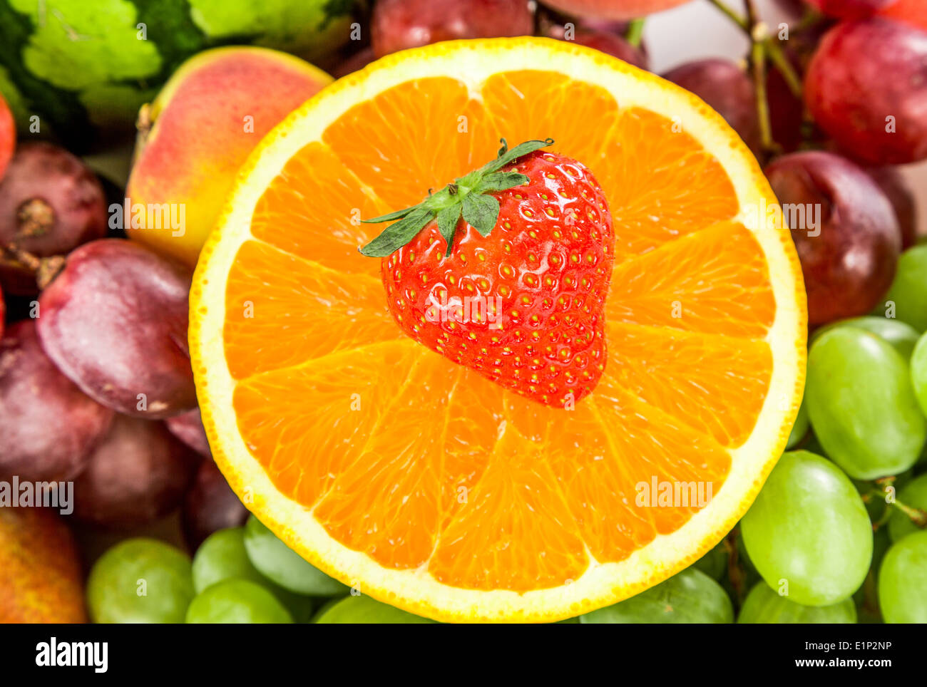 Succo di arancia e fragole su uno sfondo di diversi tipi di frutta e uva Foto Stock