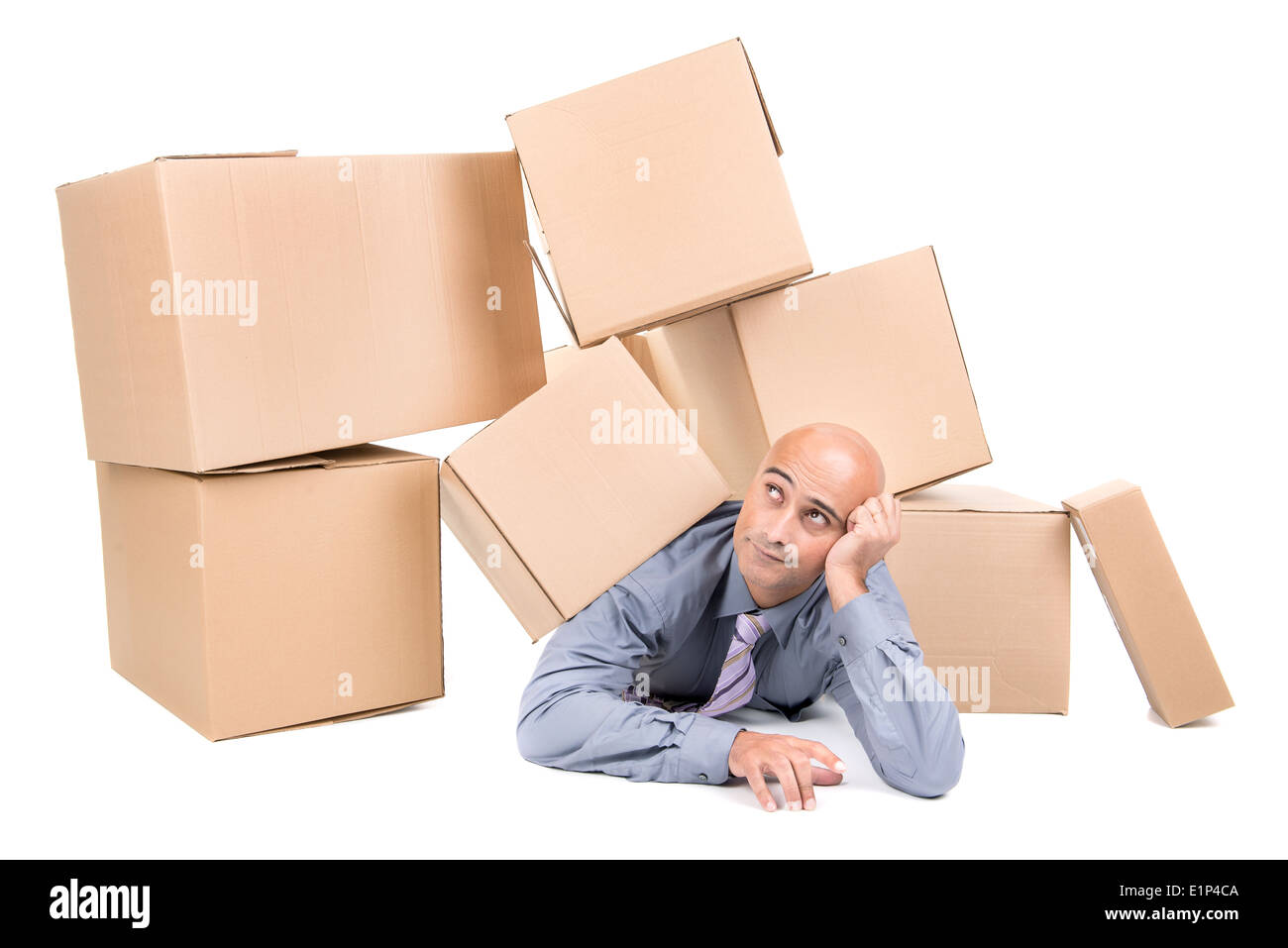 Imprenditore annoiato sotto una pila di scatole di cartone Foto Stock