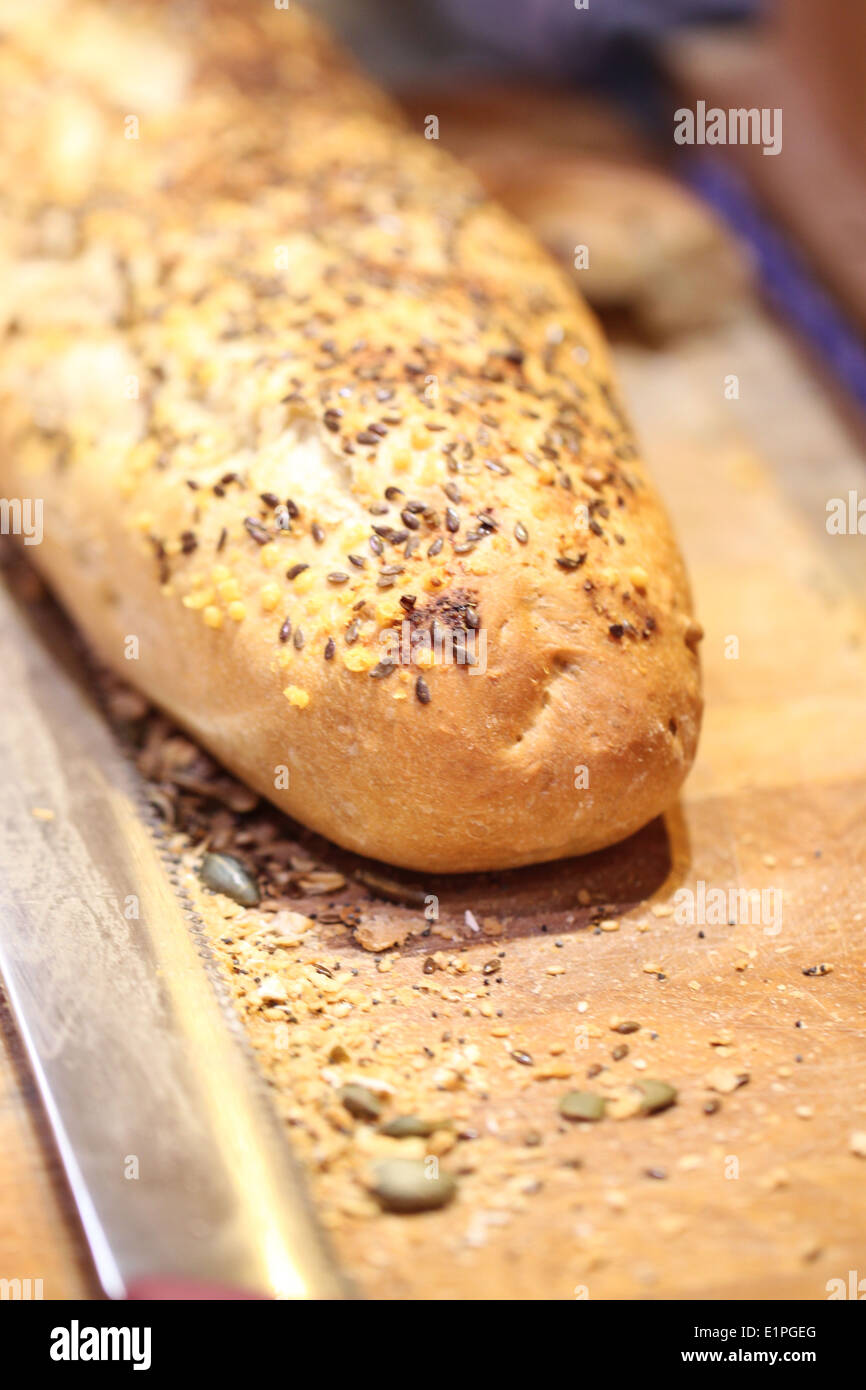 Pasta di pane cotto al forno con semi di papavero e coltello di taglio sul tagliere. Foto Stock