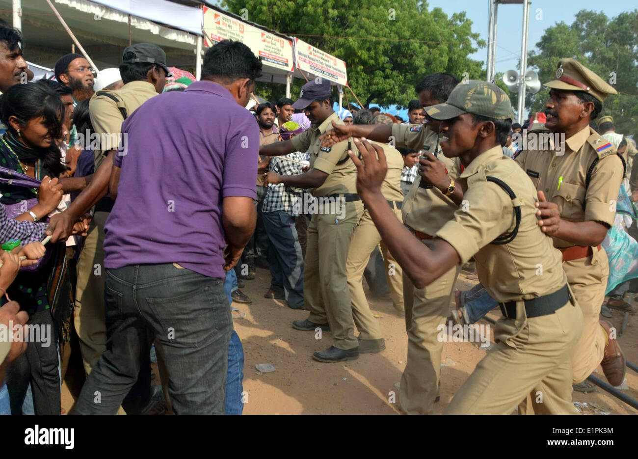 Hyderabad. 8 Giugno, 2014. Poliziotti di provare a controllare l'asma pazienti correndo per ricevere una speciale "pesci medicina' auspicio che esse li guarirà in Hyderabad, India Il 8 giugno 2014. Iniziata da Bathini Goud famiglia, la terapia è una formula segreta di erbe, tramandate da generazioni solo ai membri della famiglia. Le erbe sono inseriti nella bocca di un vivere la sardina, o pesce murrel e infilata nella gola del paziente. Credito: Stringer/Xinhua/Alamy Live News Foto Stock