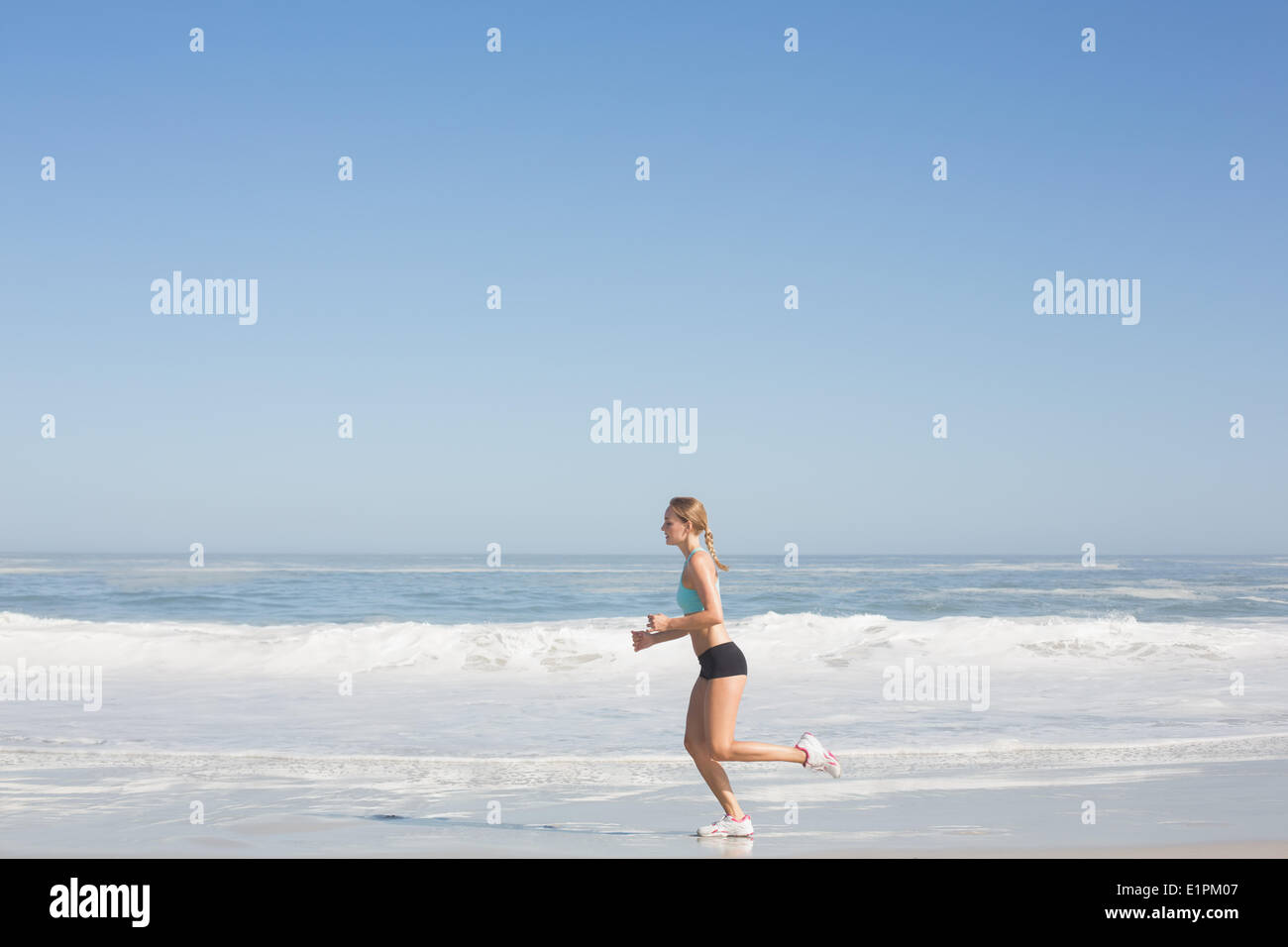 Montare donna jogging sulla spiaggia Foto Stock
