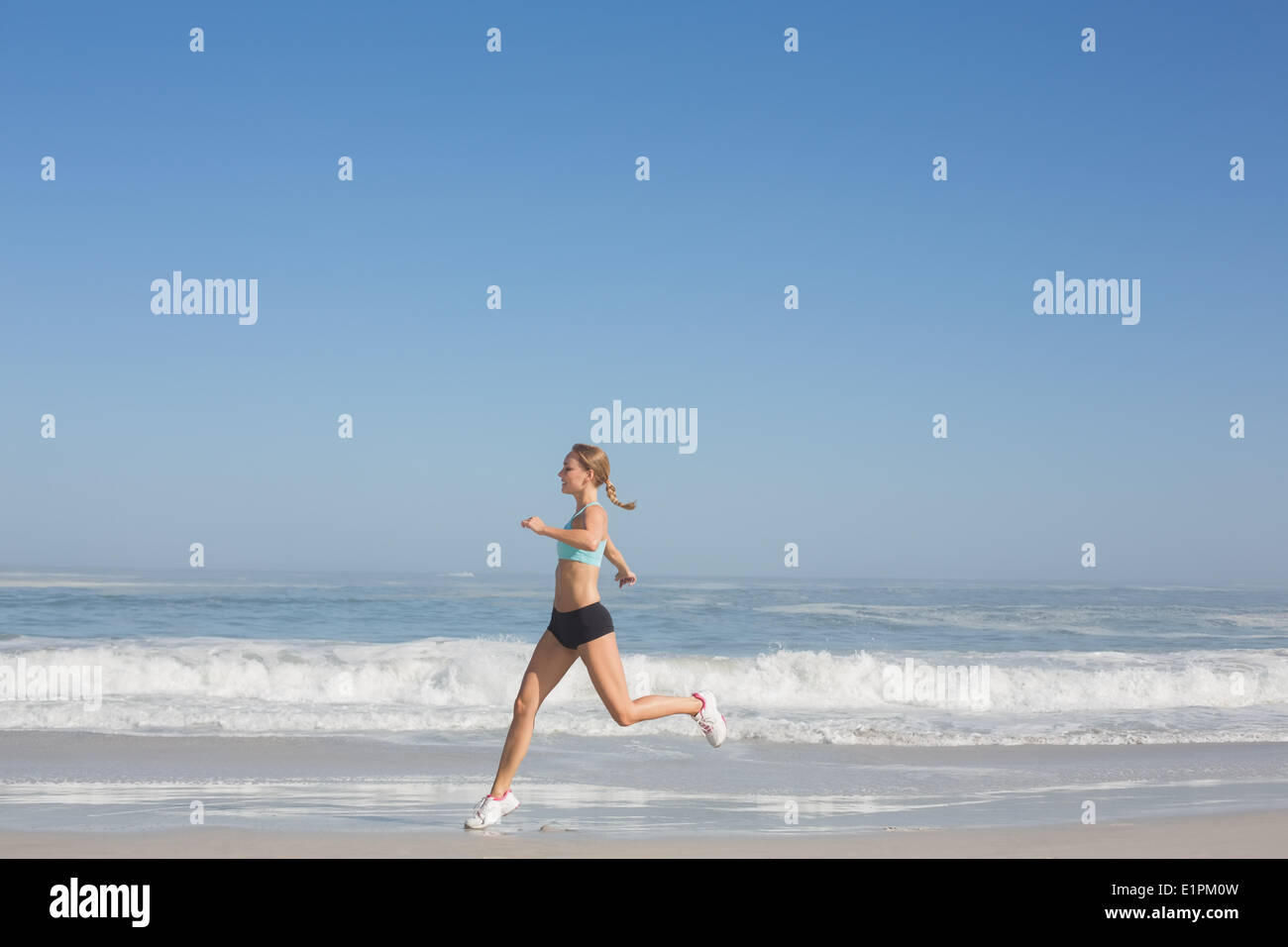 Montare donna jogging sulla spiaggia Foto Stock