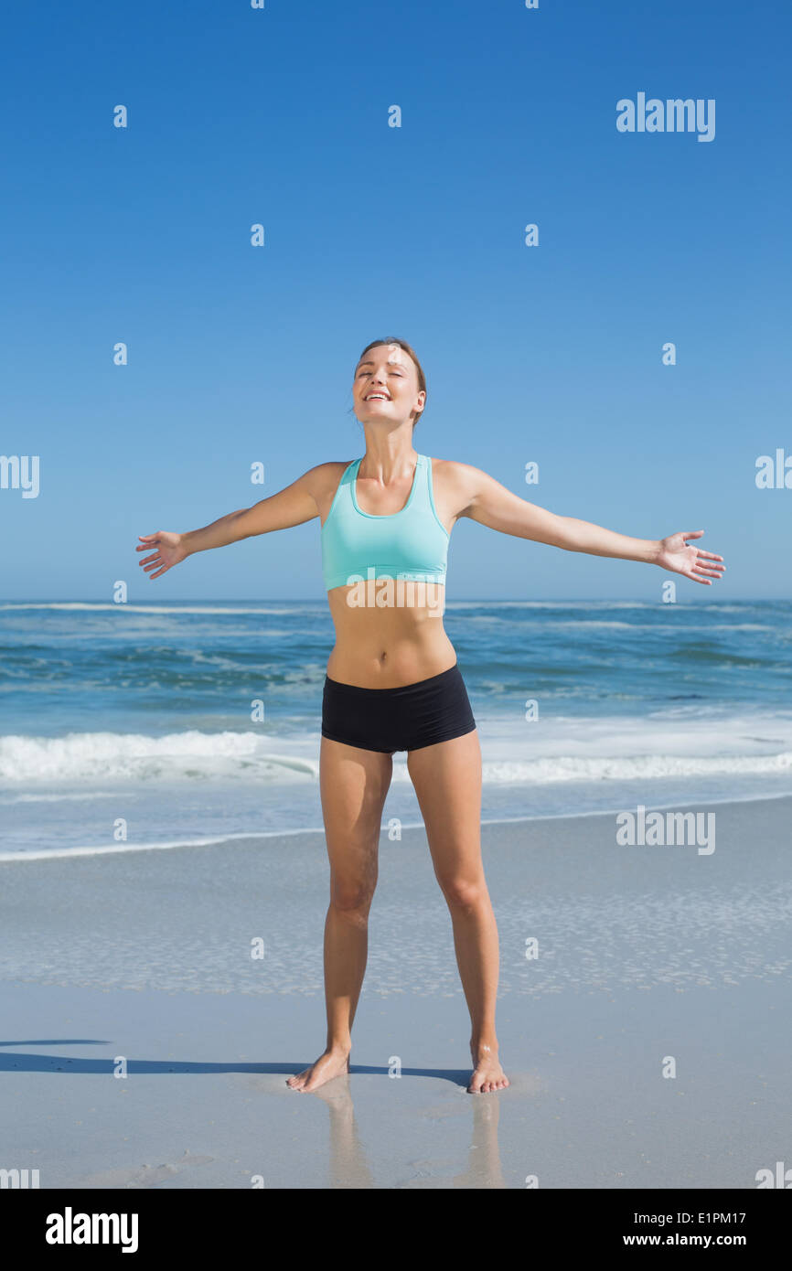 Montare donna in piedi sulla spiaggia con braccia Foto Stock