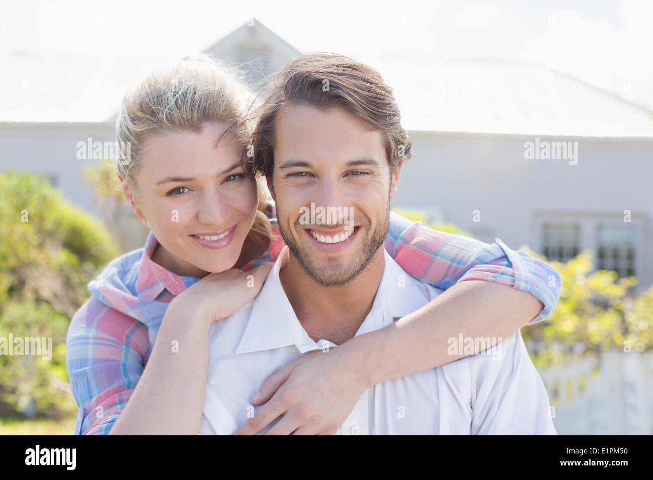 Carino Coppia sorridente in telecamera insieme nel loro giardino Foto Stock