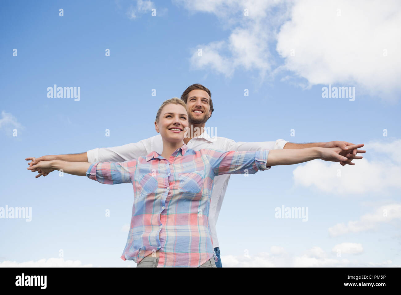 Coppia felice in piedi al di fuori con le braccia tese Foto Stock