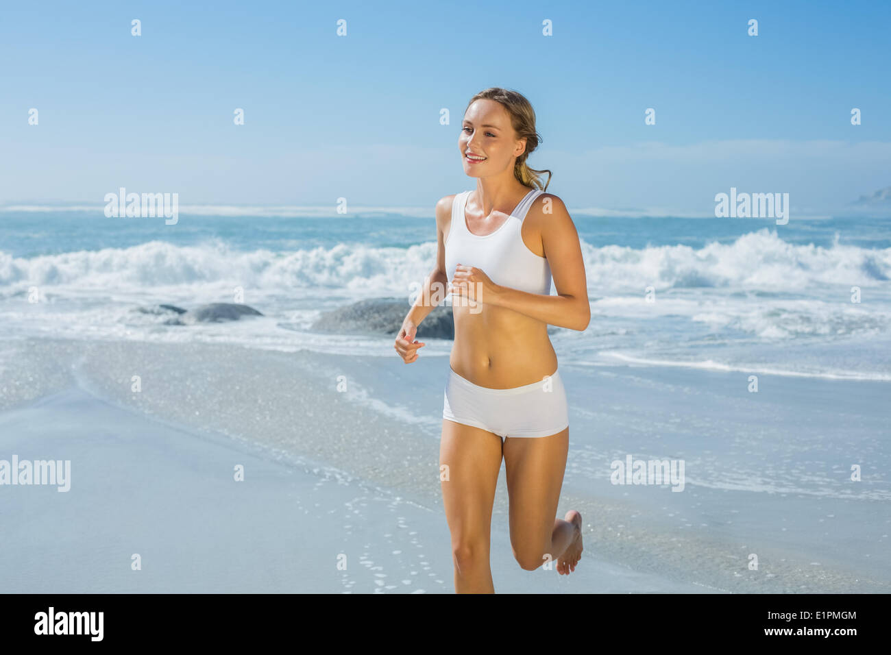 Montare splendida bionda jogging in riva al mare Foto Stock
