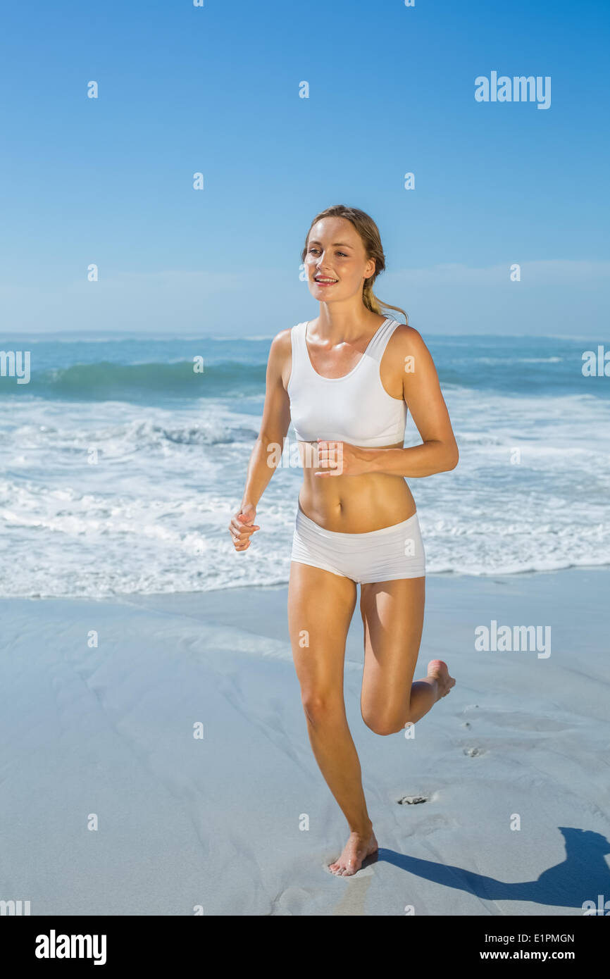 Montare splendida bionda jogging in riva al mare Foto Stock