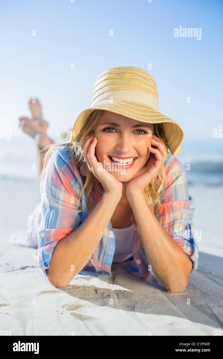 Bella bionda sorridente in telecamera in spiaggia distesi sulla sabbia Foto Stock