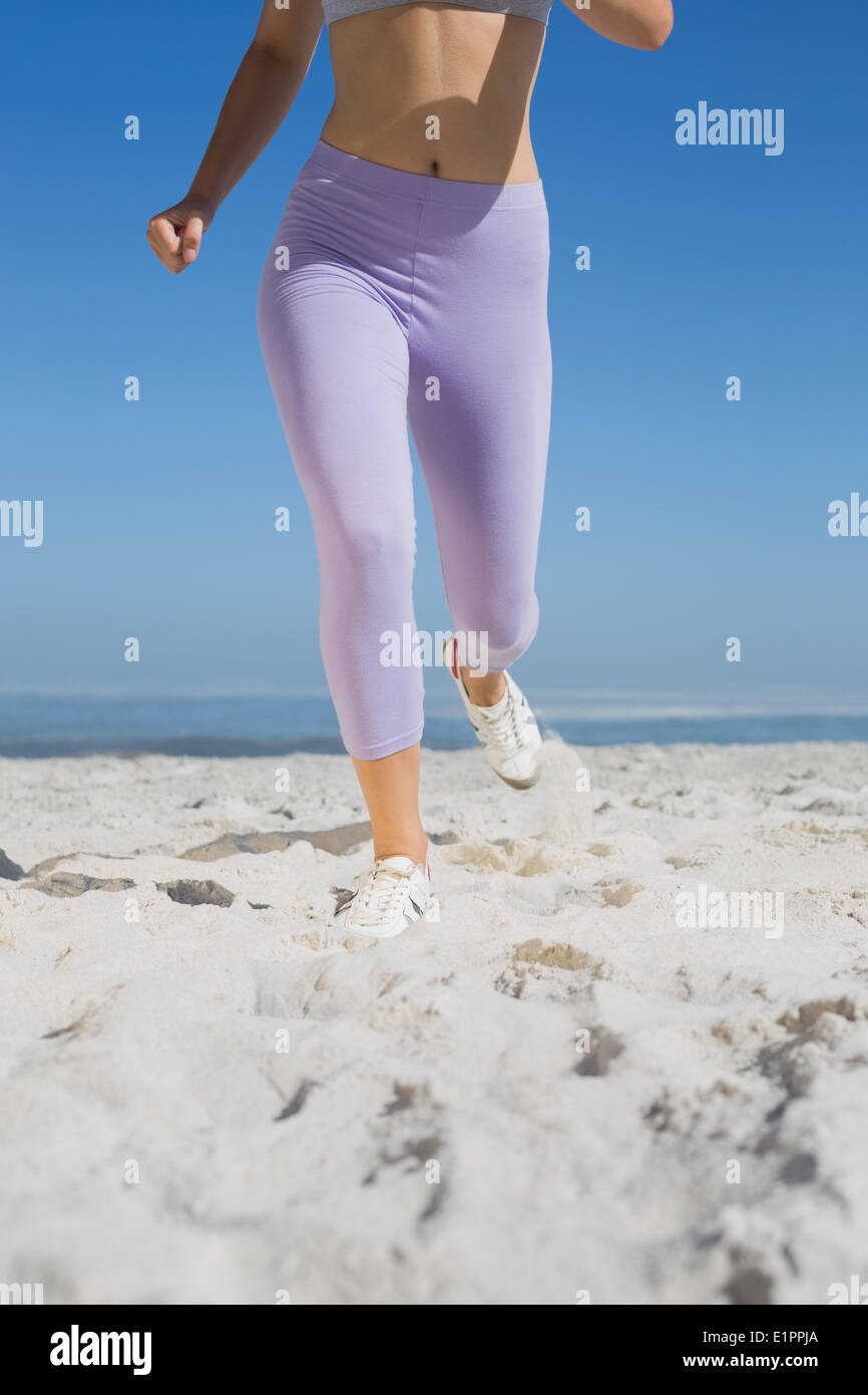 Sportivo gambe womans sulla sabbia Foto Stock