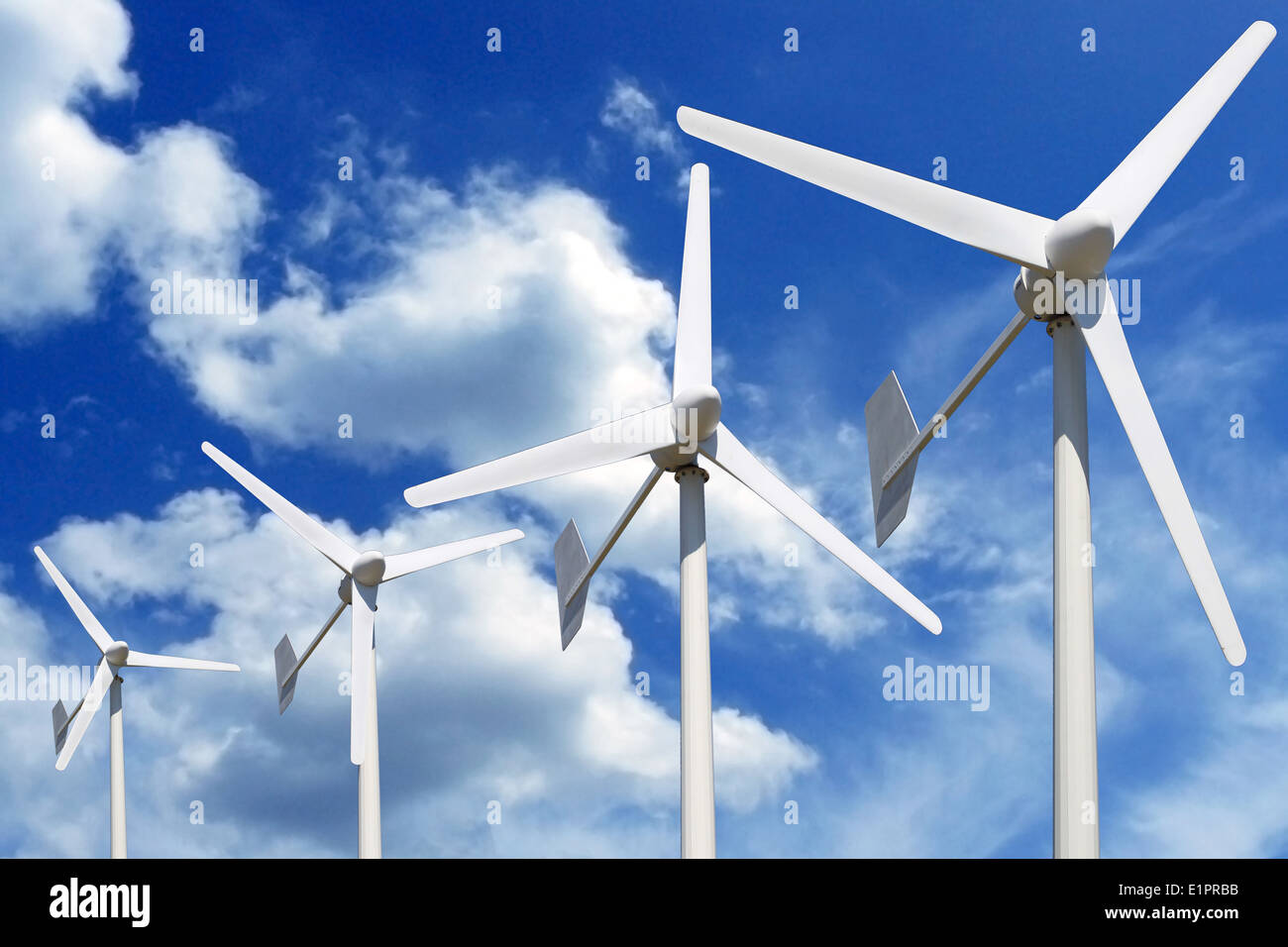 Più turbine eoliche online cielo blu con nuvole Foto Stock