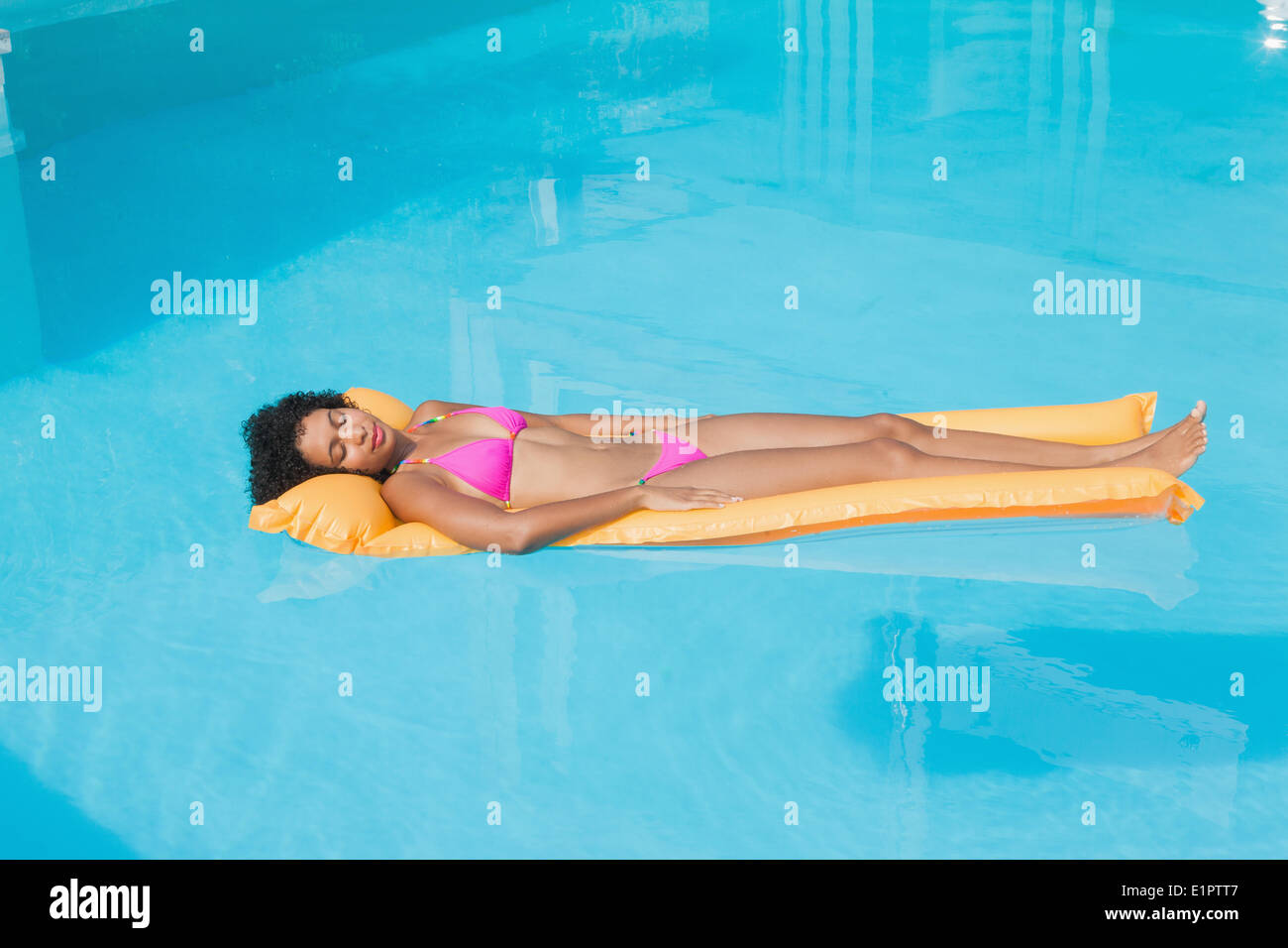Montare donna sdraiata su lilo in piscina Foto Stock
