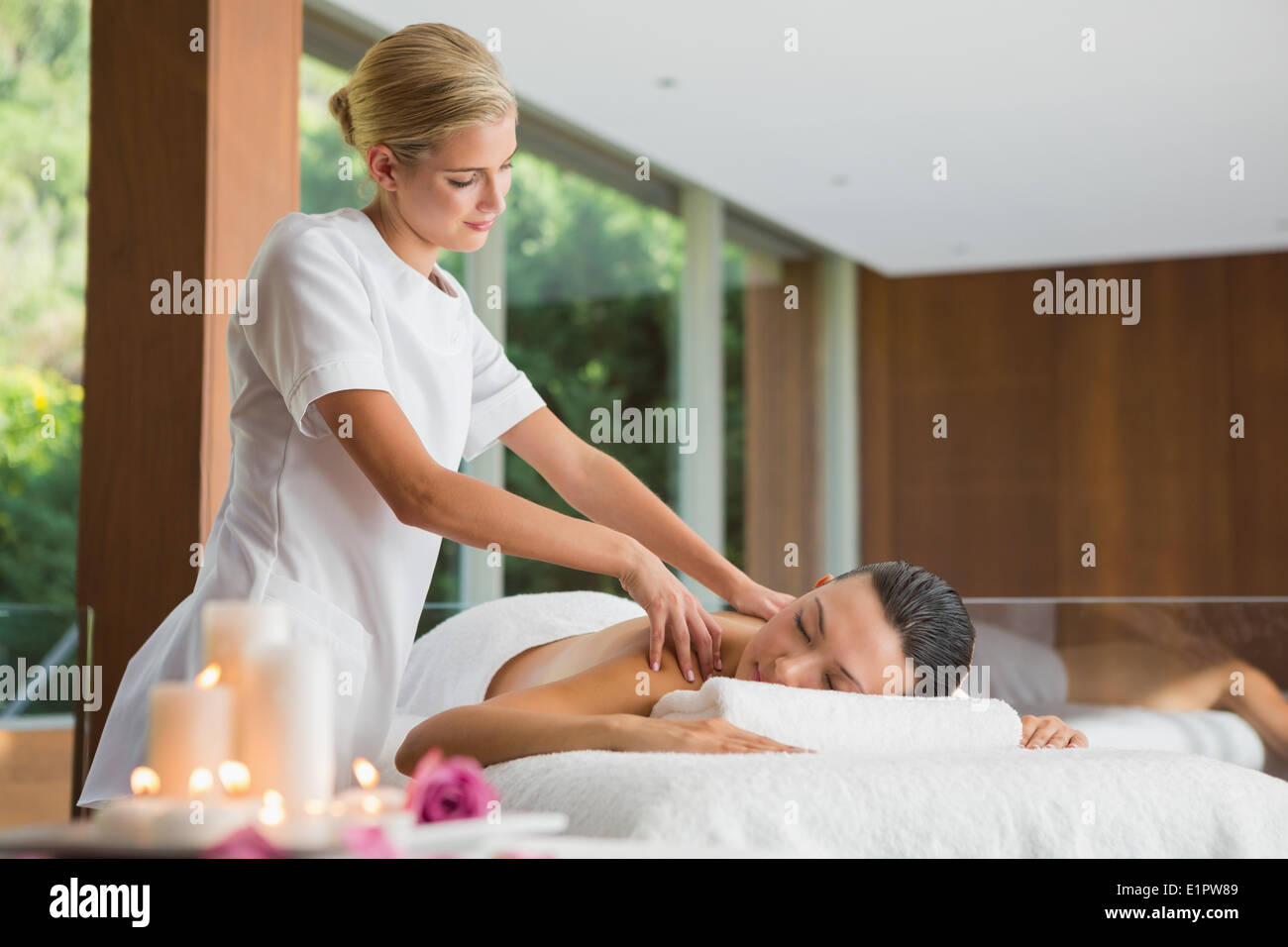 Sorridente brunette ottenendo un massaggio della spalla Foto Stock