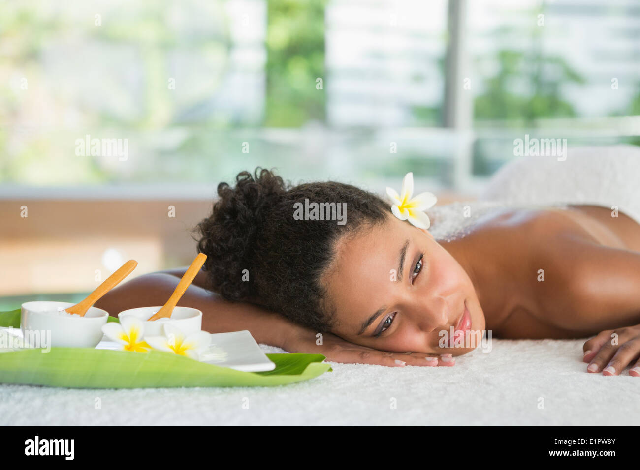 Donna Gorgeous sdraiato sul lettino da massaggio con sale trattamento sul retro Foto Stock