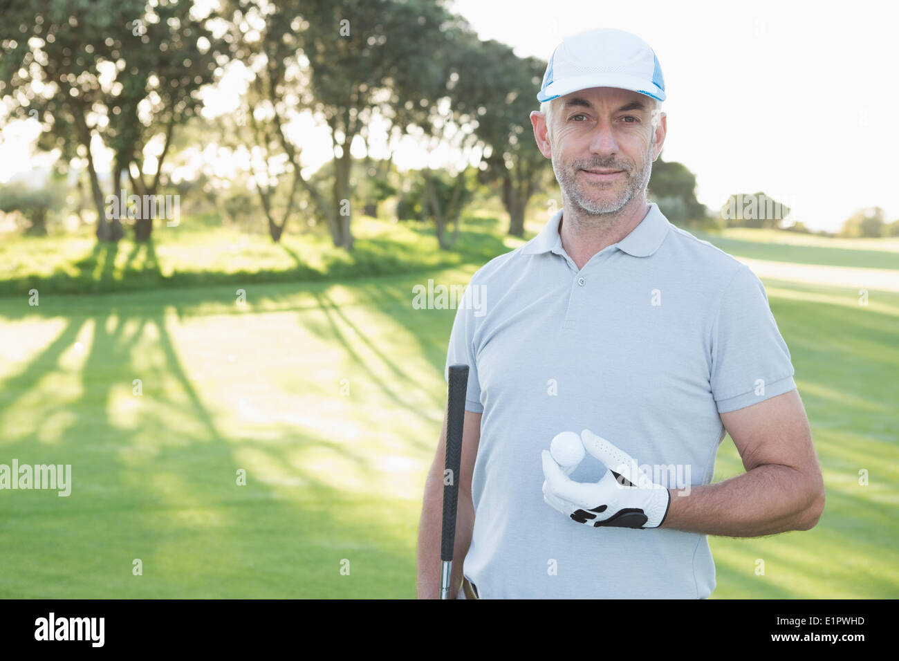 Bello il golfer in piedi con la pallina da golf Foto Stock