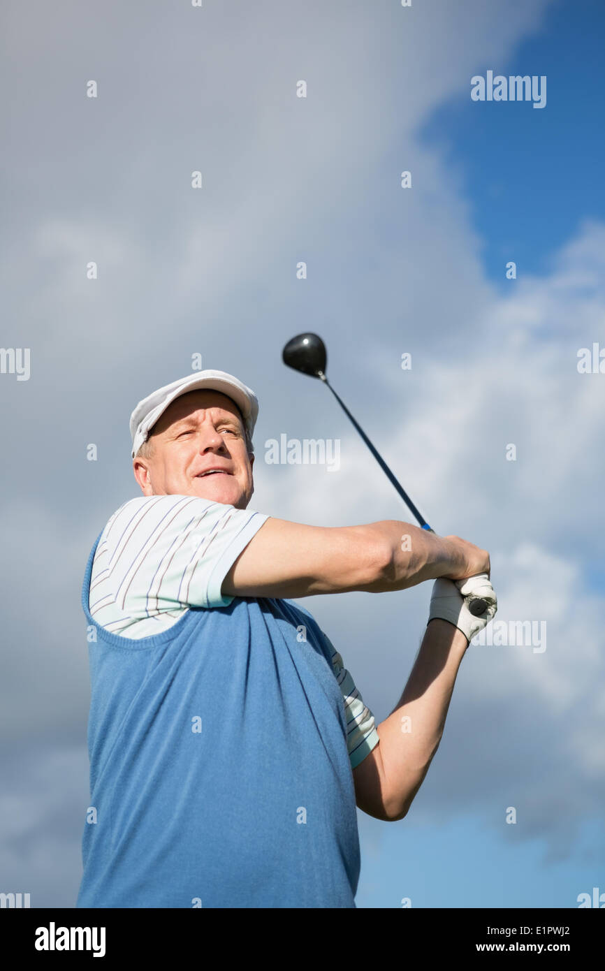 Il Golfer in piedi ed oscillante il suo club Foto Stock