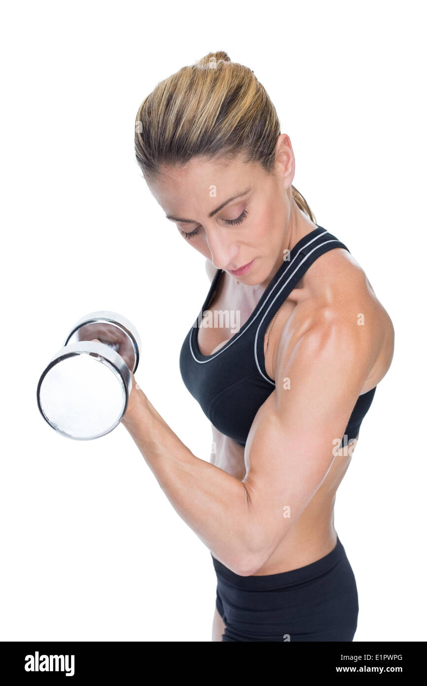 Bodybuilder femminile tenendo un grande dumbbell guardando al bicipite Foto Stock