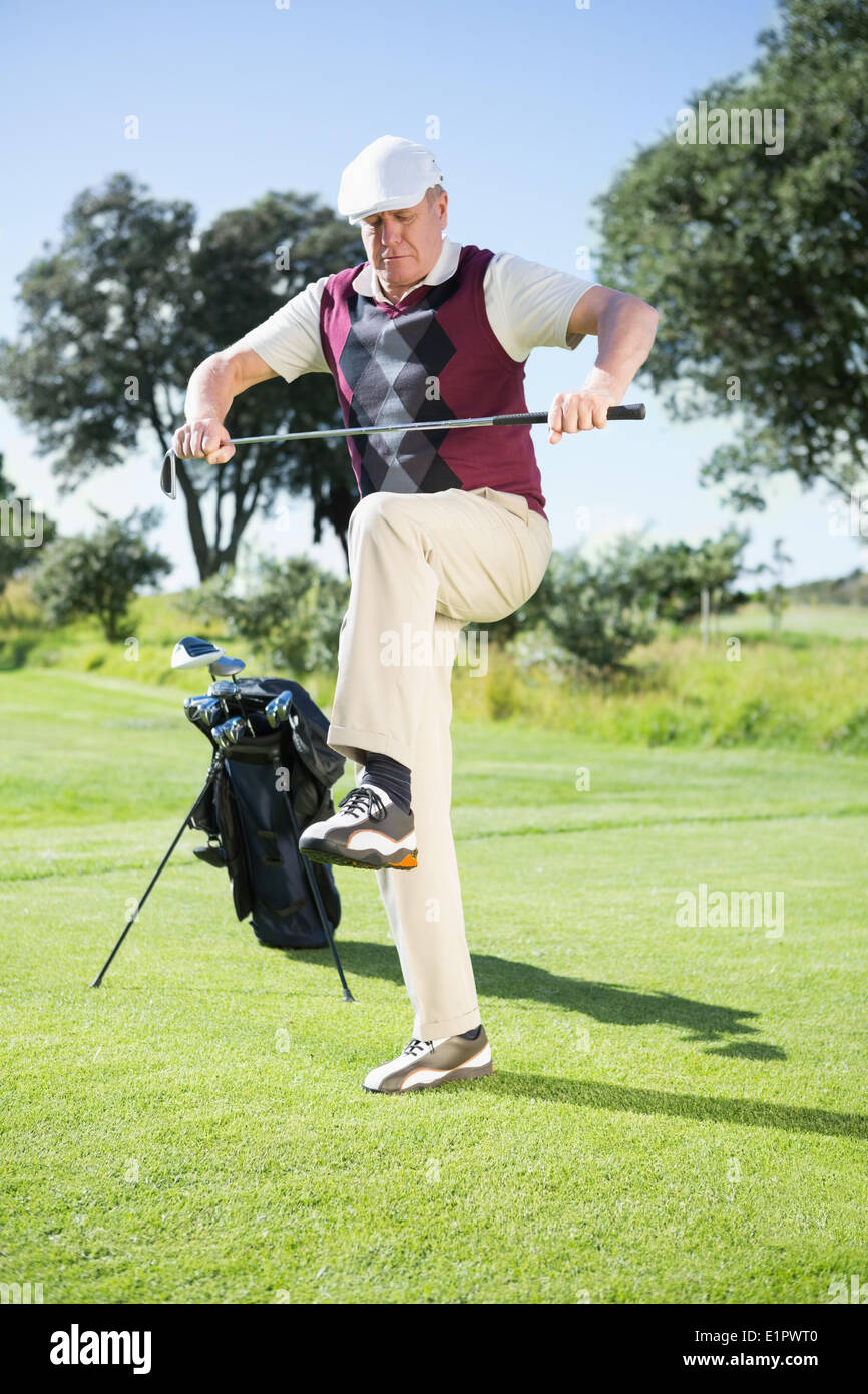 Arrabbiato golfista cercando di rompere il suo club Foto Stock