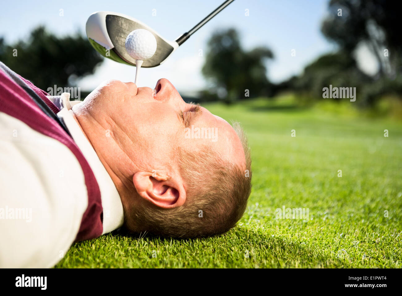 Il Golfer tenendo il raccordo a T nel suo denti Foto Stock