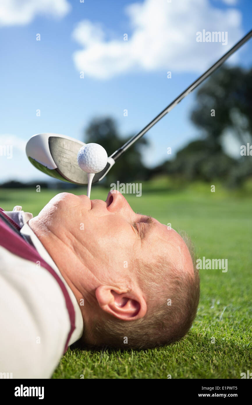 Il Golfer tenendo il raccordo a T nel suo denti Foto Stock
