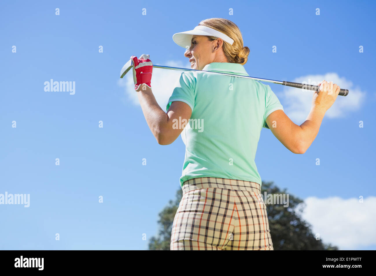 Giocatore di golf femminile in piedi mentre tiene il suo club Foto Stock