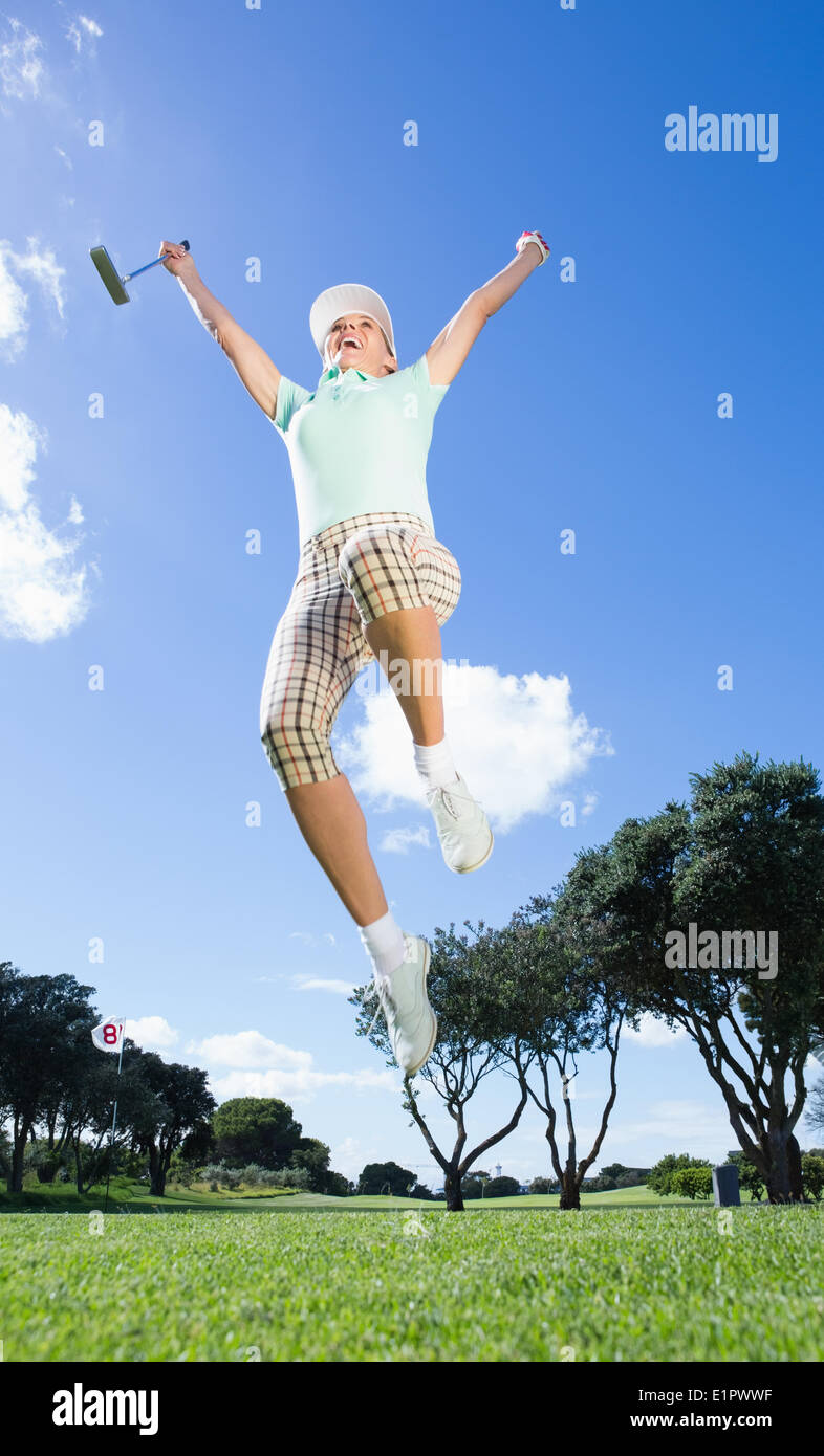 Giocatore di golf femminile che saltava e rasserenanti Foto Stock
