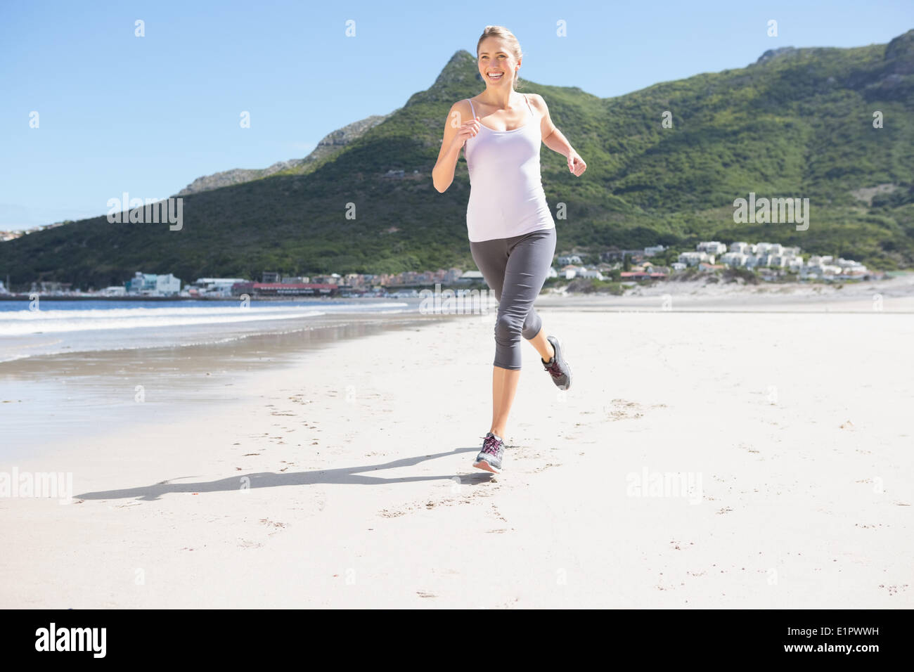 Bella bionda jogging sulla spiaggia Foto Stock