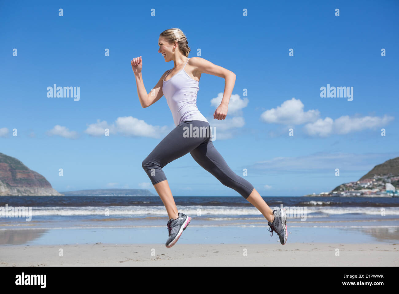 Piuttosto montare bionda jogging sulla spiaggia Foto Stock