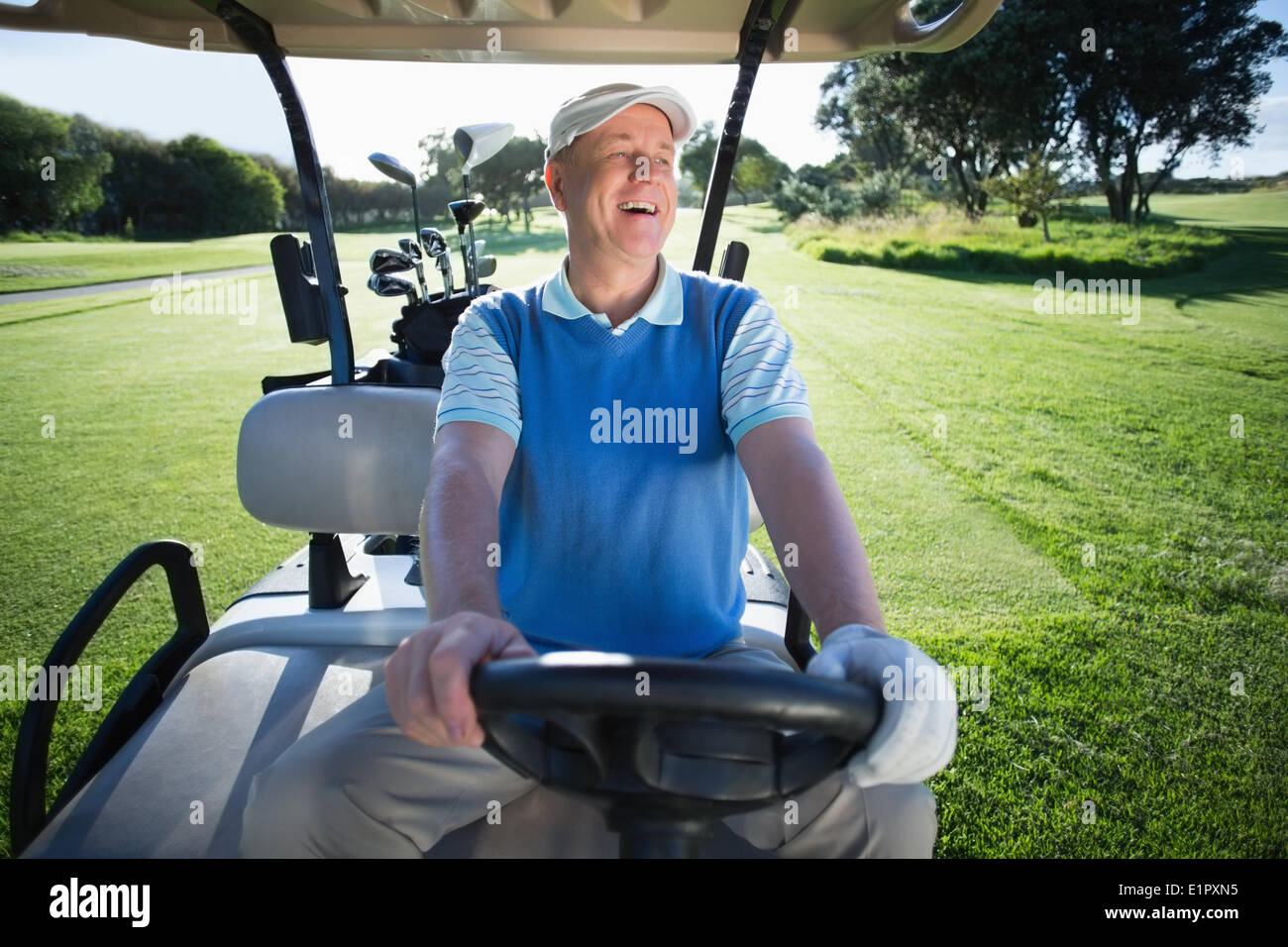Felice golfista alla guida della sua golf buggy Foto Stock