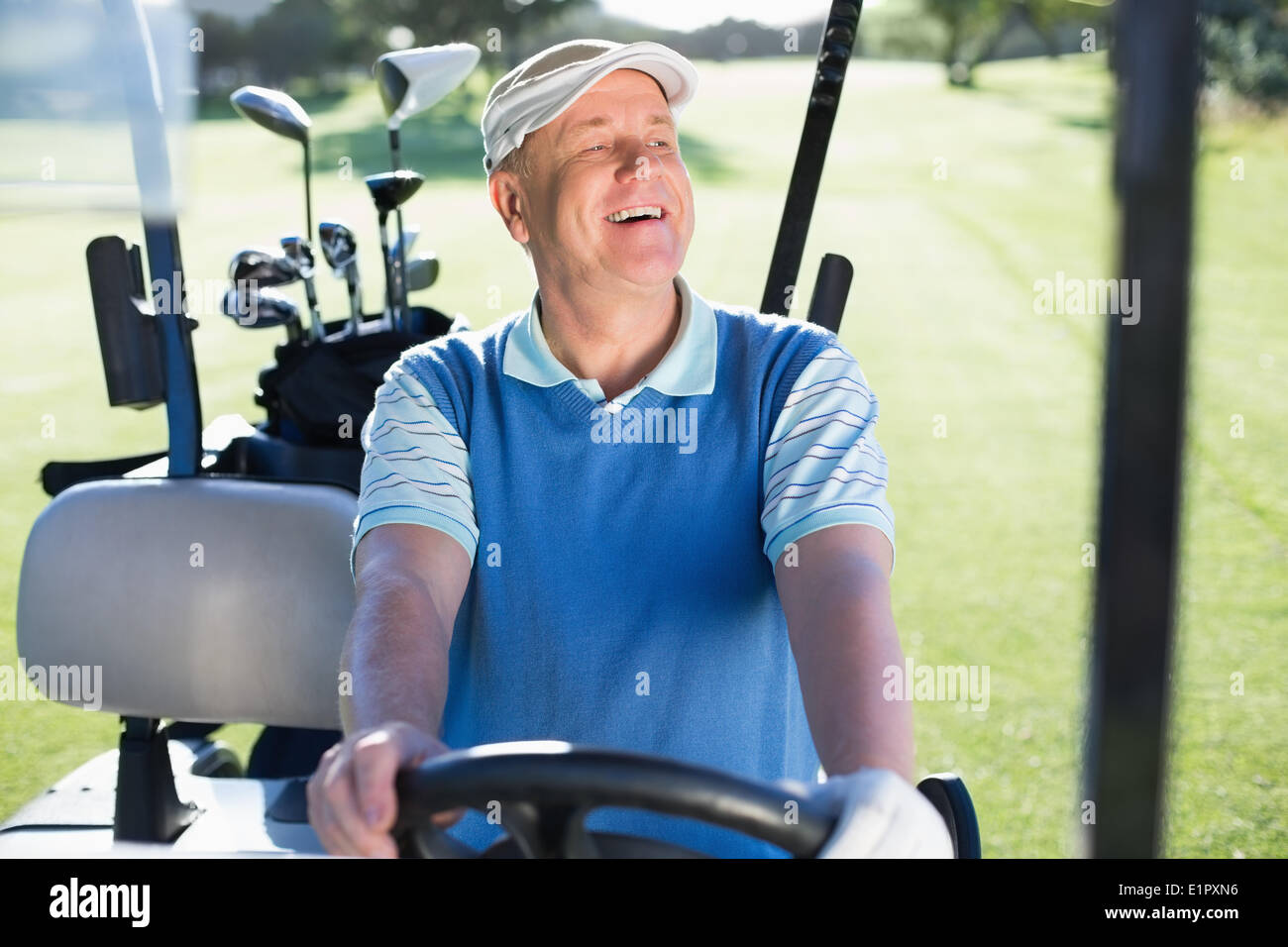 Felice golfista alla guida della sua golf buggy Foto Stock