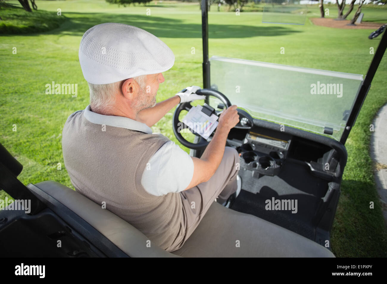 Felice golfista alla guida della sua golf buggy Foto Stock