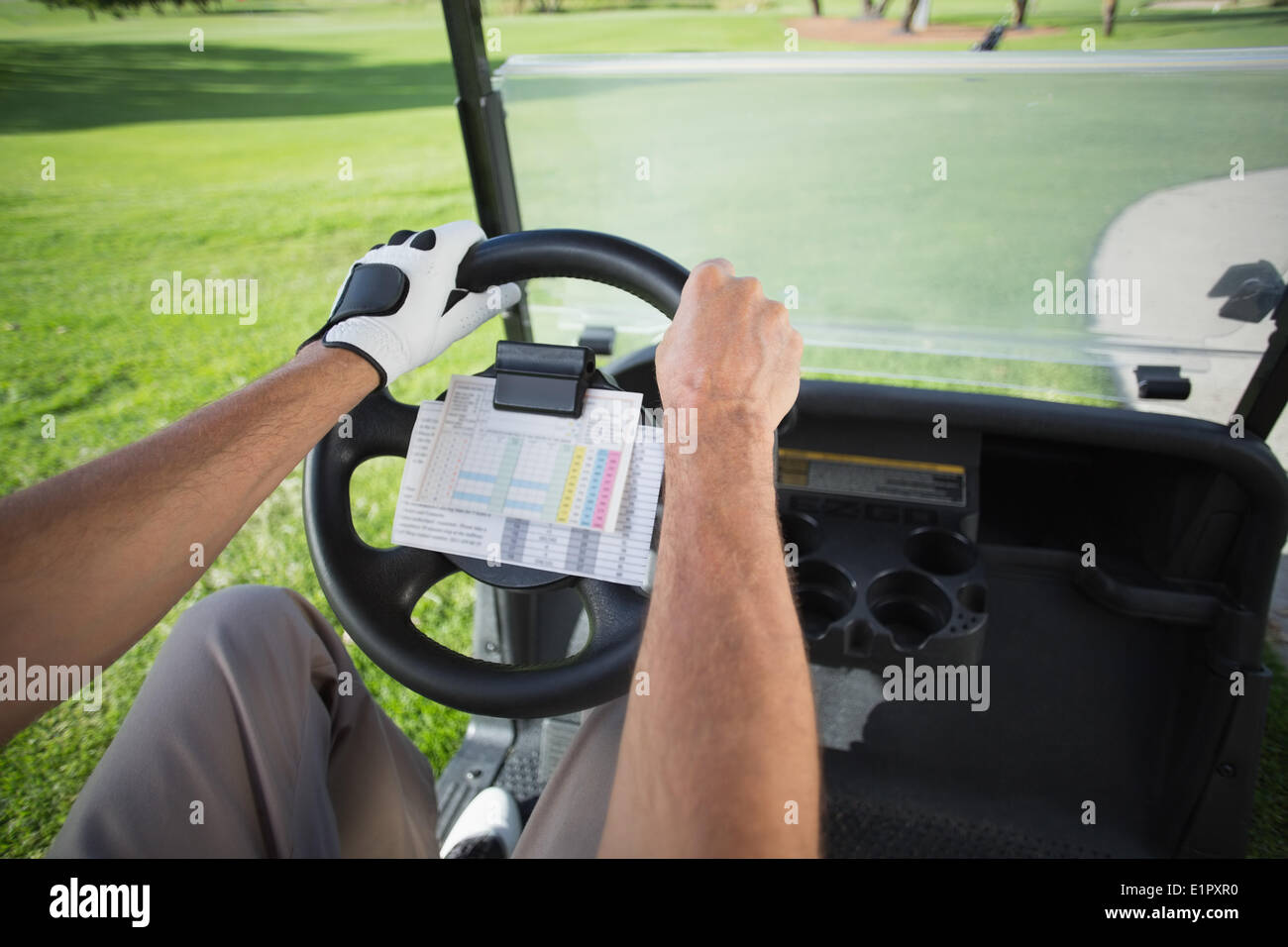 Il Golfer alla guida della sua golf buggy in avanti Foto Stock