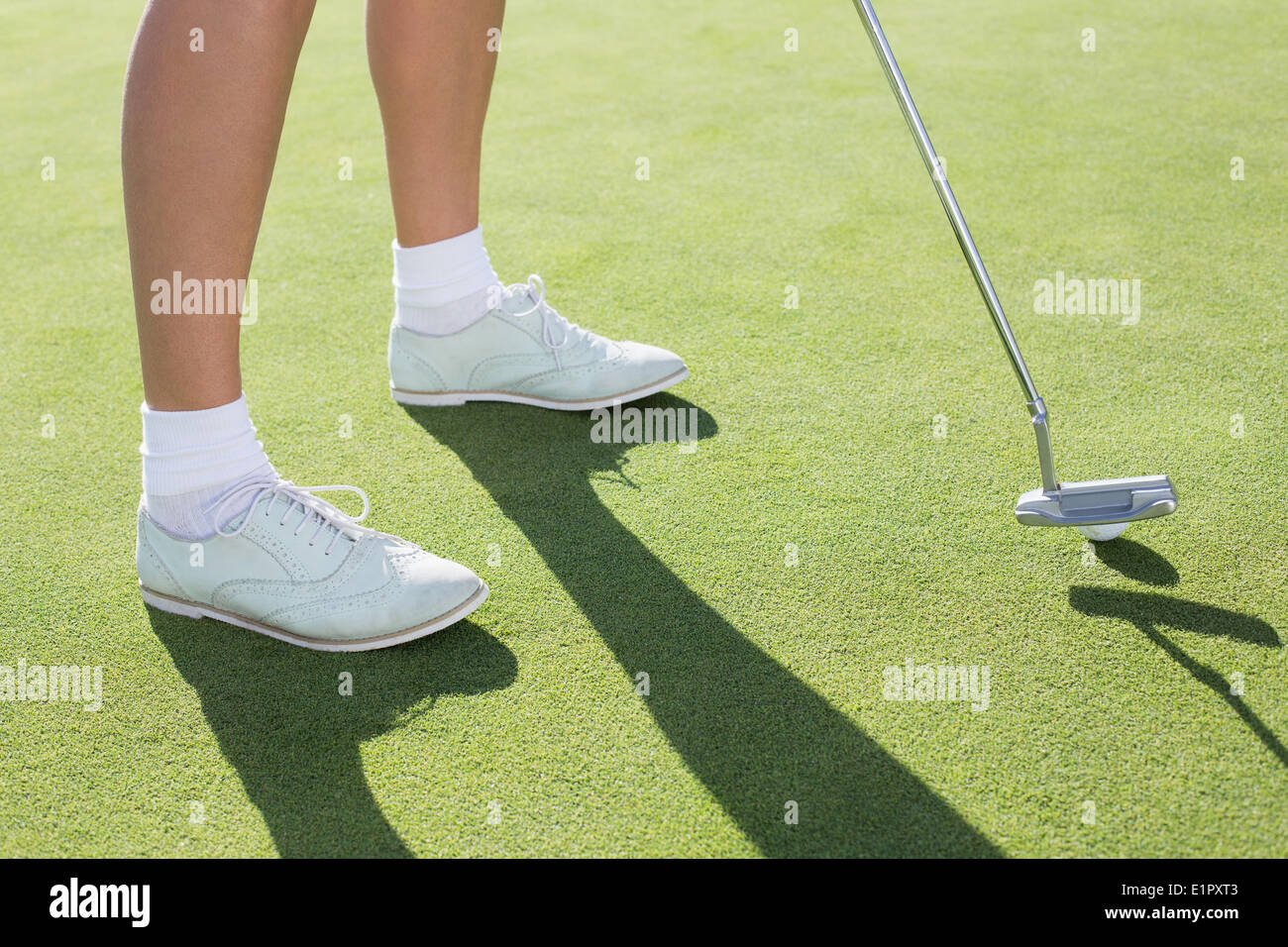 Signora golfista sul putting green Foto Stock