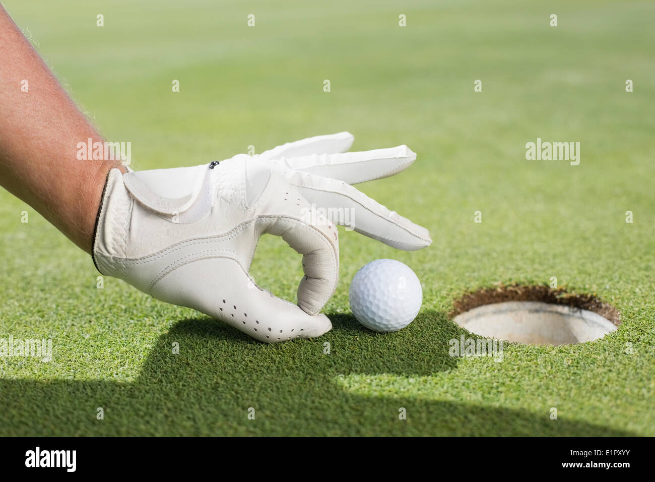 Il Golfer cercando di sfiorare la sfera nel foro Foto Stock