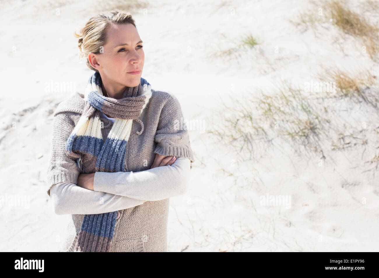 Attraente bionda permanente sulla spiaggia di lana sciarpa Foto Stock