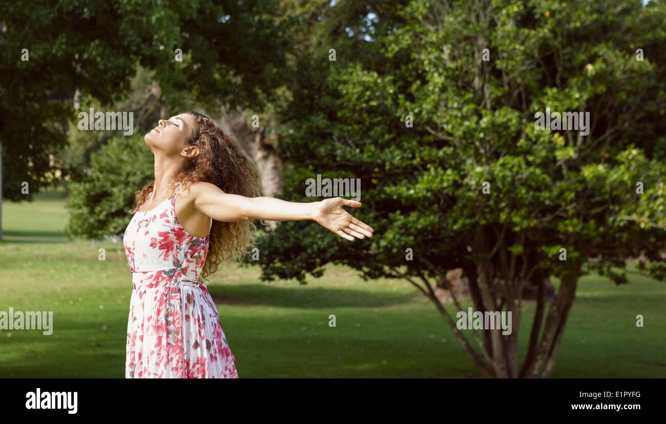 Bella donna in abiti estivi in piedi con le braccia Foto Stock