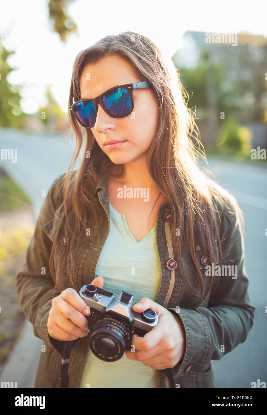 Close up lifestyle ritratto di pretty moda giovane brunette in occhiali da sole su il sole al tramonto Foto Stock