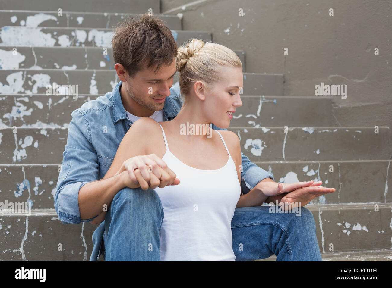 Hip coppia giovane seduto sui gradini mostrando affetto Foto Stock