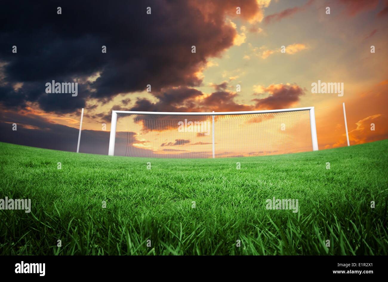 Campo di calcio sotto nuvoloso cielo arancione Foto Stock