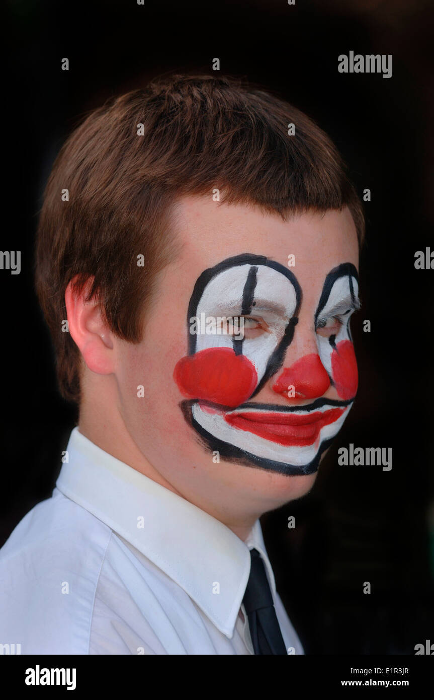 Uomo adolescenti con un dipinto di clown faccia. Foto Stock
