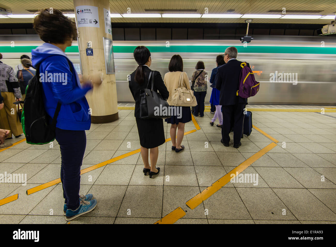 La gente sulla linea di attesa per il treno della metropolitana, Kyoto, Giappone Foto Stock