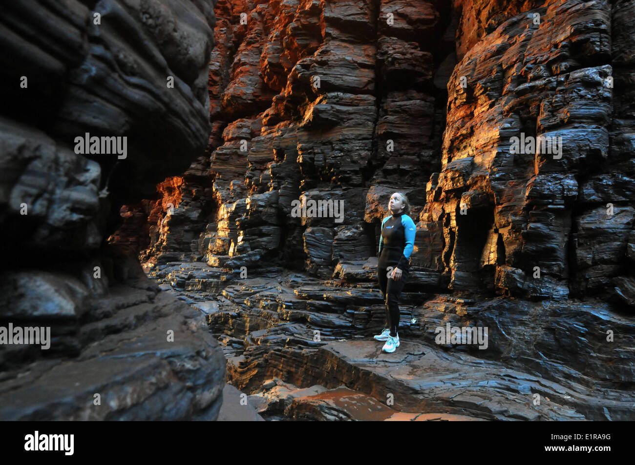 Canyoner femmina nella muta in fondo Weano Gorge, Karijini National Park, regione Pilbara, Western Australia. No signor Foto Stock