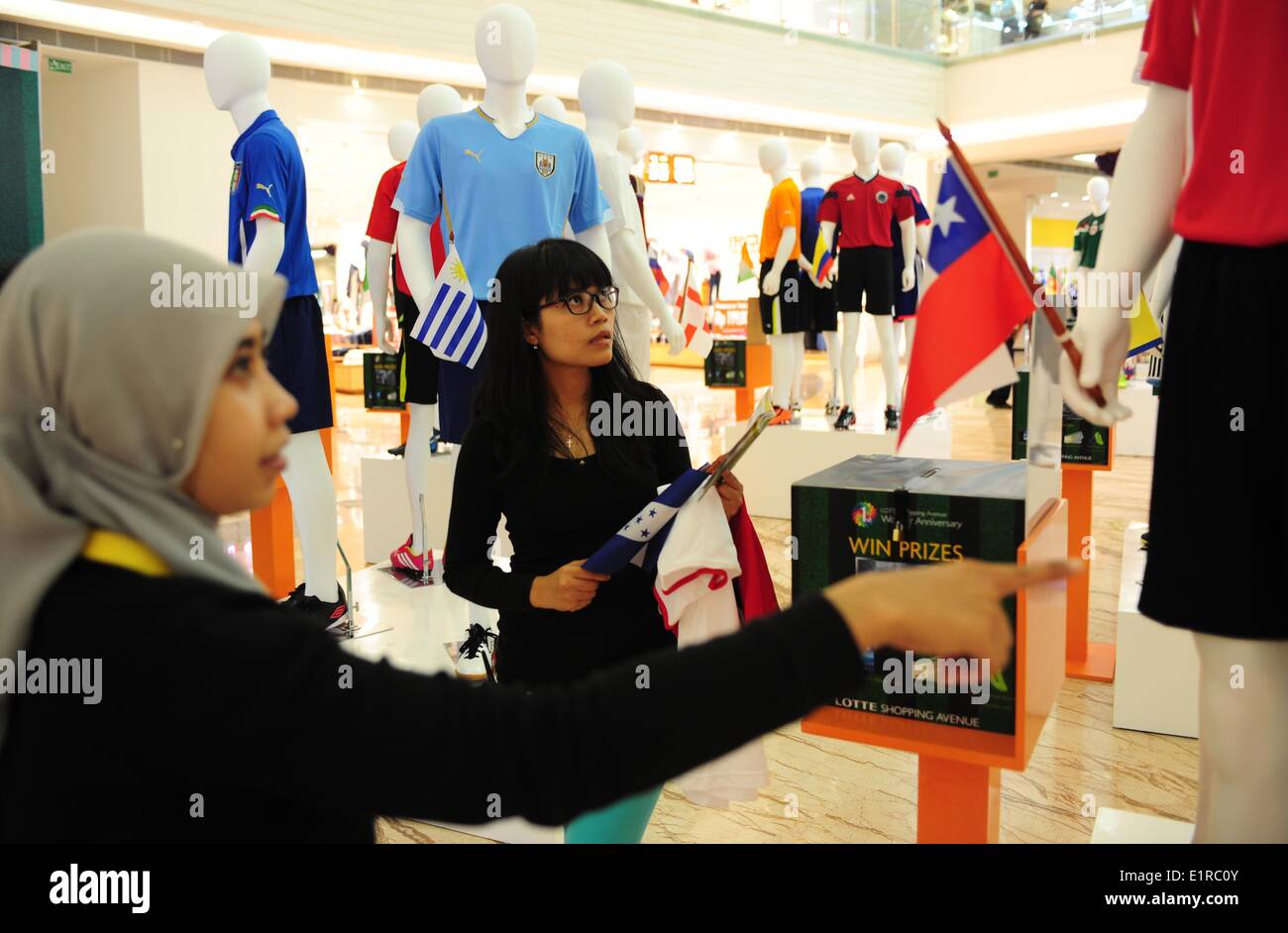 (140609) -- JAKARTA, 9 giugno 2014 (Xinhua) -- dipendenti preparare manichini in Coppa del Mondo di maglie dei paesi partecipanti a un centro commerciale per lo shopping di Jakarta, Indonesia, 9 giugno 2014. Il 2014 Fifa World Cup si aprirà ufficialmente il 12 giugno. (Xinhua/Zulkarnain) Foto Stock